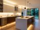 Bright modern kitchen glowing with warm under-cabinet LED strip lights.